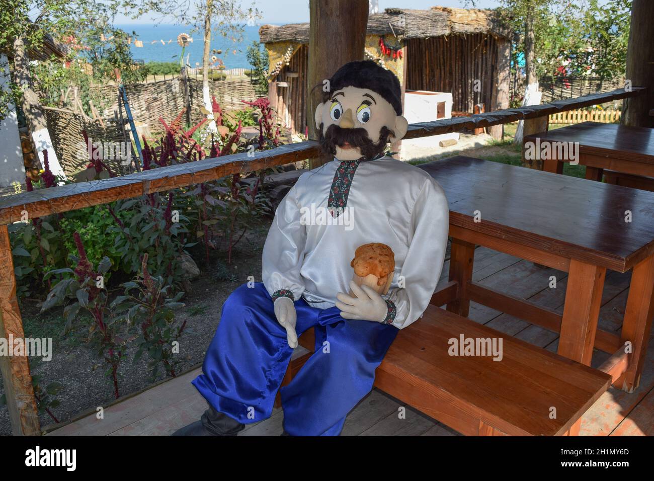 Cosaco muñeca sentada en un banco con una cerveza. Recrear la imagen histórica. Foto de stock