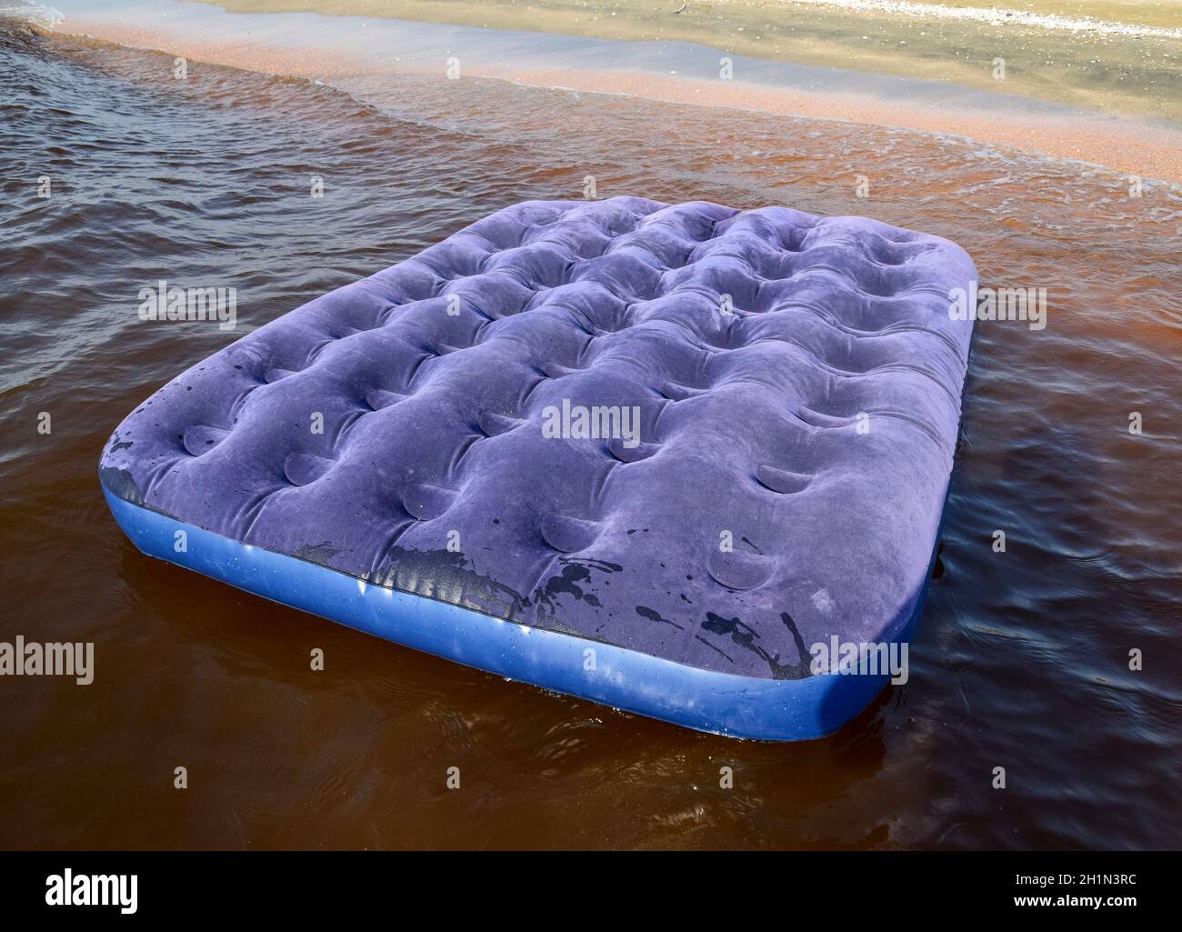Colchón inflable azul nadando en el estanque. Un colchón inflable en la  playa Fotografía de stock - Alamy