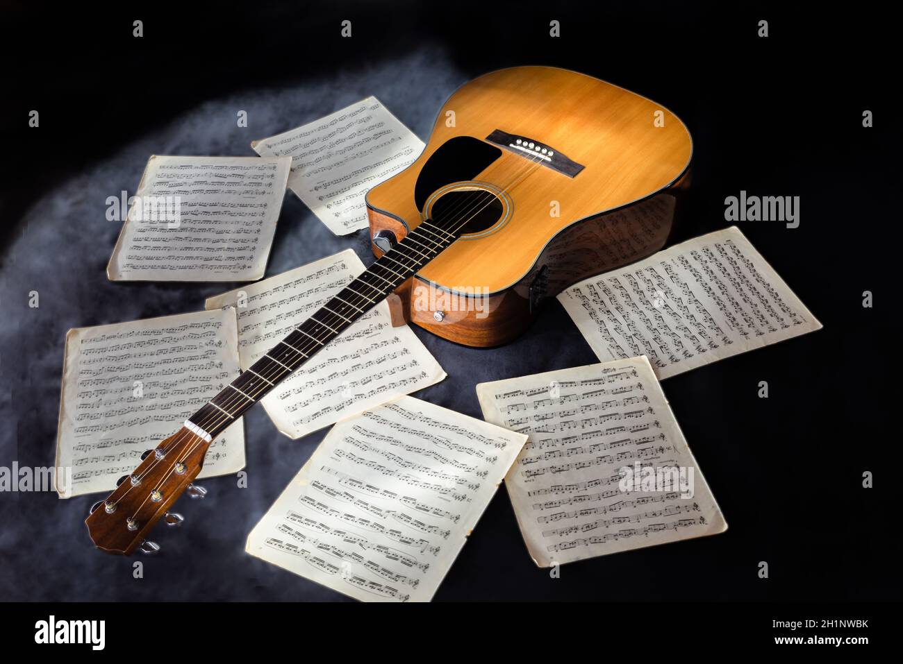 letras de guitarra acústica de seis cuerdas y partituras de color amarillo  clásico con notas sobre fondo negro aislado rodeado de niebla Fotografía de  stock - Alamy