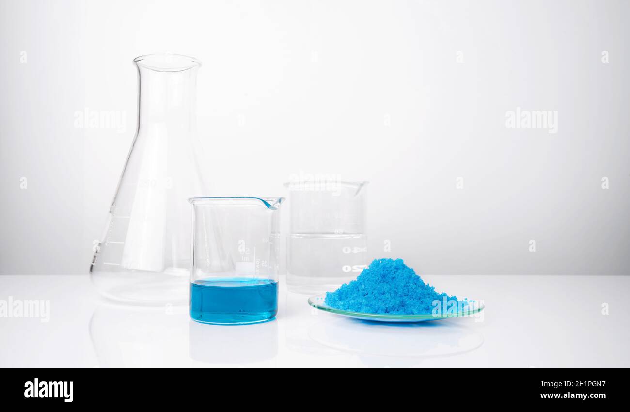 Cierre el químico inorgánico en la mesa blanca del laboratorio. Sulfato de cobre (II), alcohol. Ingrediente químico para productos cosméticos y artículos de tocador. Foto de stock
