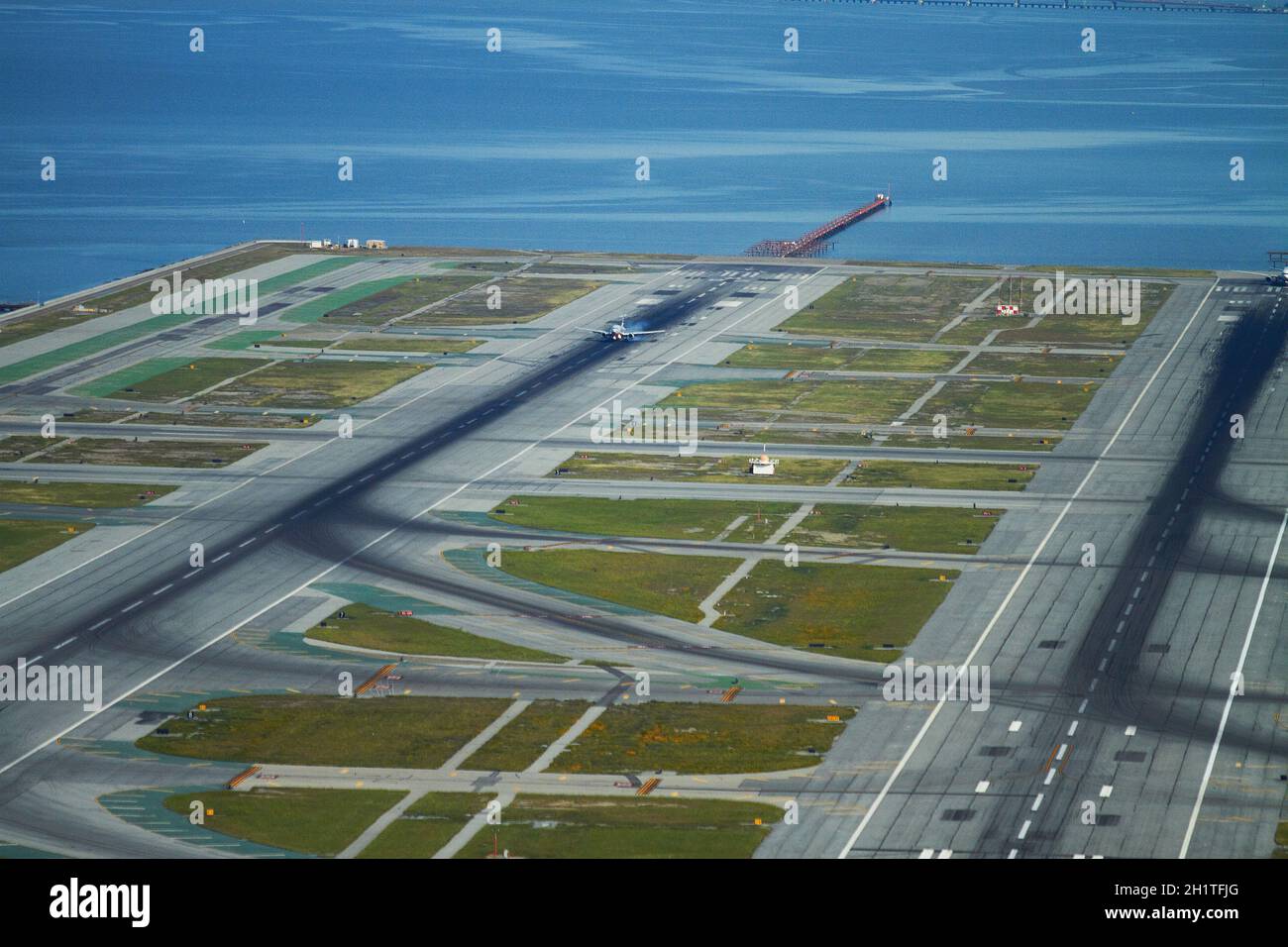 Aérea de avión tocando la pista, el Aeropuerto Internacional de San Francisco y la Bahía de San Francisco, San Francisco, California, Estados Unidos. Foto de stock