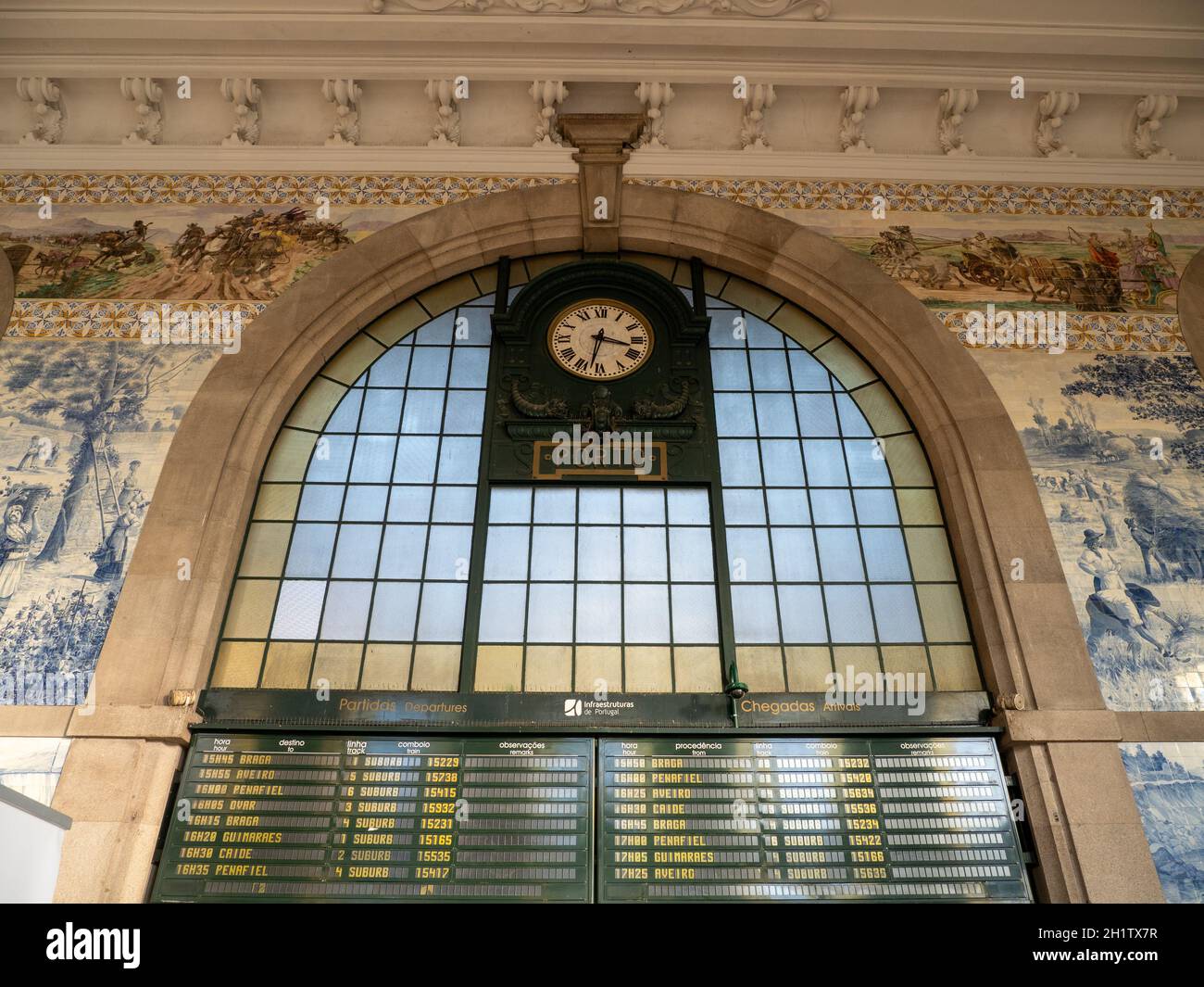 Hall de entrada de la estación de tren de Sao Bento con horario de trenes,  reloj de la estación, Azulejo pared de azulejos, y Nombre de placa „Porto“  Fotografía de stock -