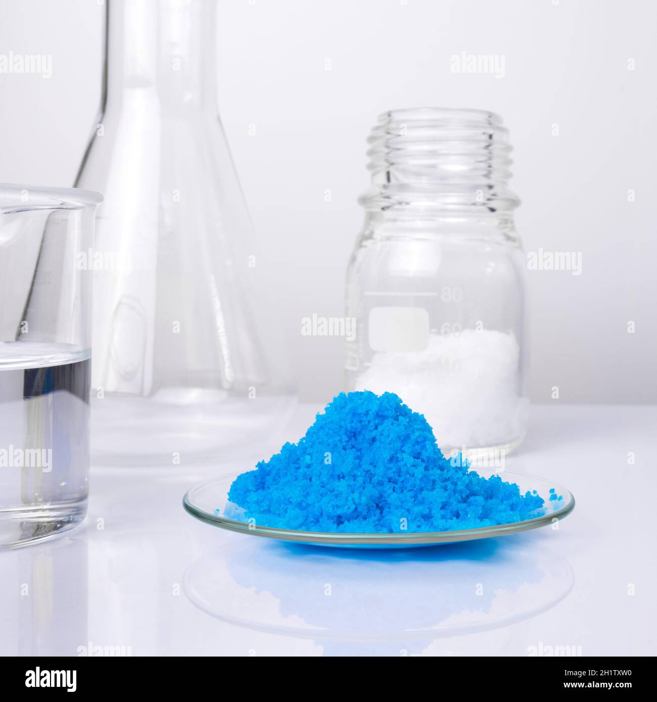 Primer plano de productos químicos inorgánicos sobre una mesa de laboratorio blanca. Sulfato de cobre (II), cera microcristalina y alcohol. Ingrediente químico para Cosméticos y TO Foto de stock