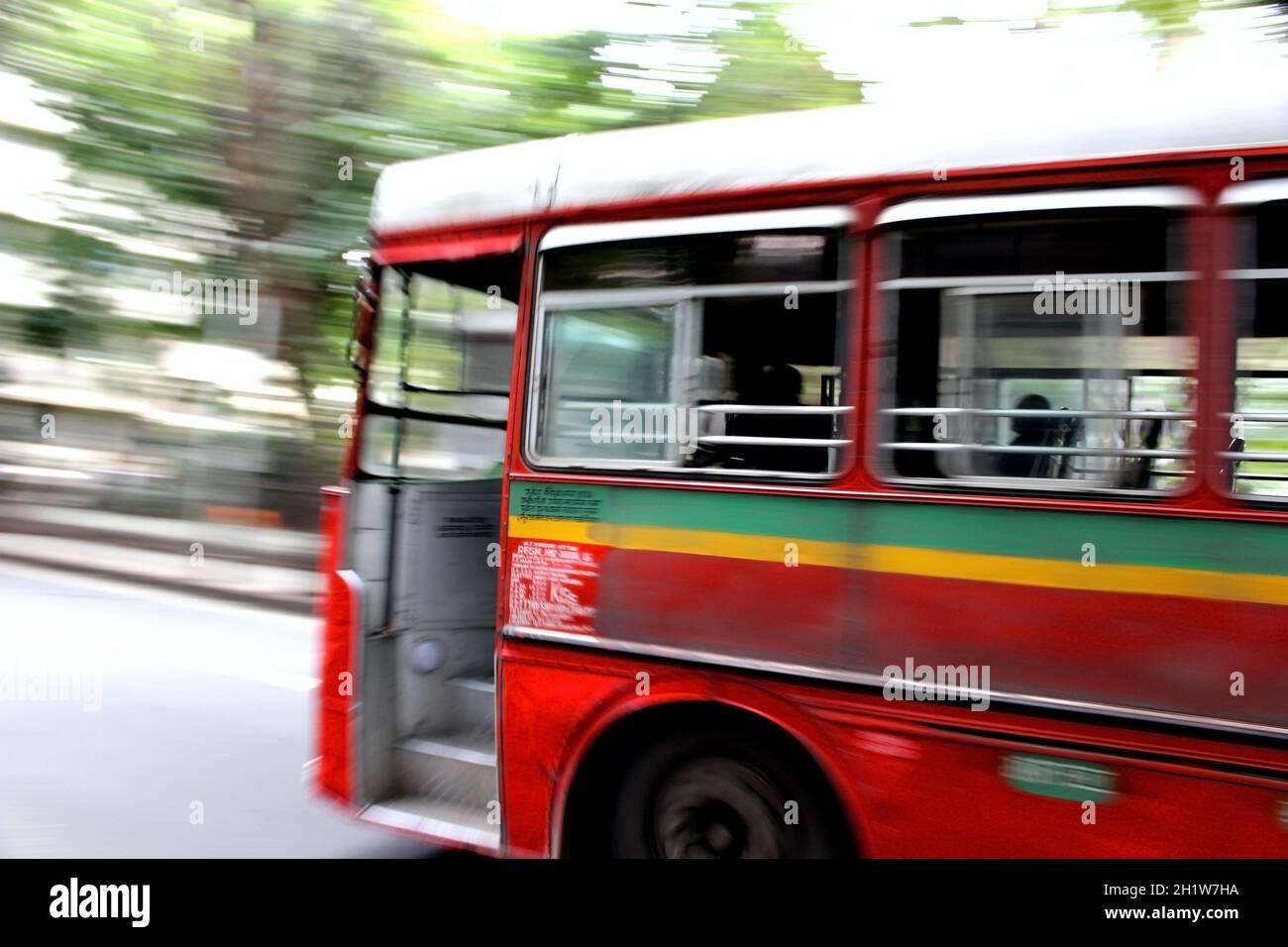 Hermoso Red Bus Tomando un giro agudo a toda velocidad en la calle de la ciudad centrada en el autobús, el fondo es el movimiento borroso, EL MEJOR autobús en Mumbai, India Foto de stock