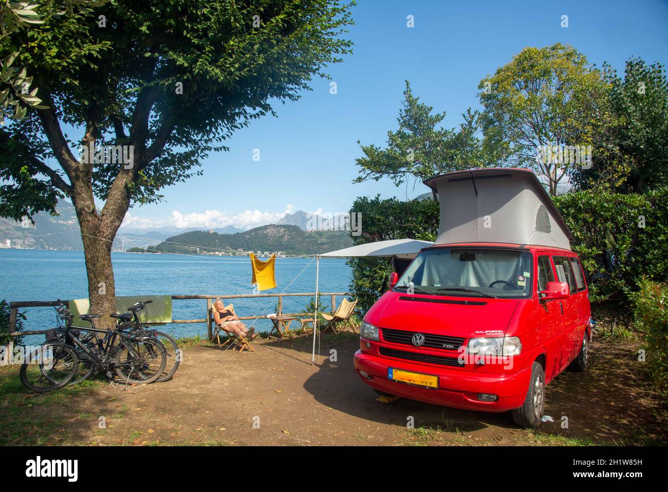 rojo VW T4 campervan en el lago Iseo en Italia Foto de stock