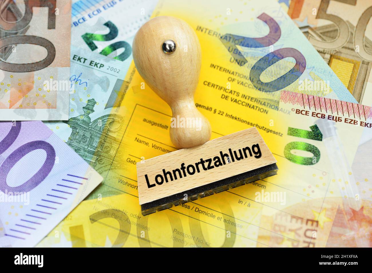Palabra alemana para el pago continuo de salarios en el estampilla que se está jugando en una tarjeta de vacunación Foto de stock