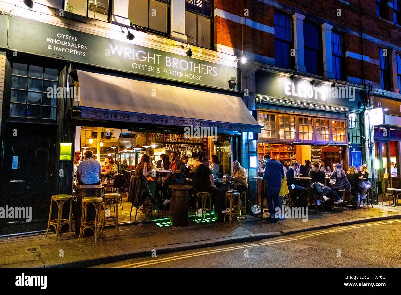 La gente cenando al aire libre por la noche en los restaurantes Borough Market, London Bridge, Londres, Reino Unido Foto de stock