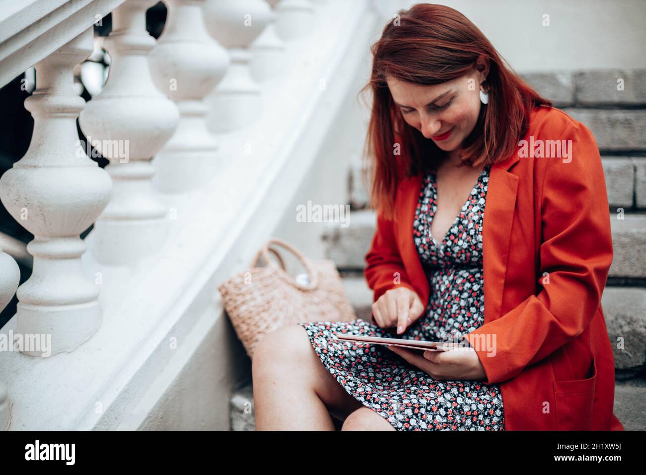 retrato de una mujer de negocios sonriente con ropa elegante el trabajo  utiliza un moderno tablet mientras está sentado en la calle Fotografía de  stock - Alamy