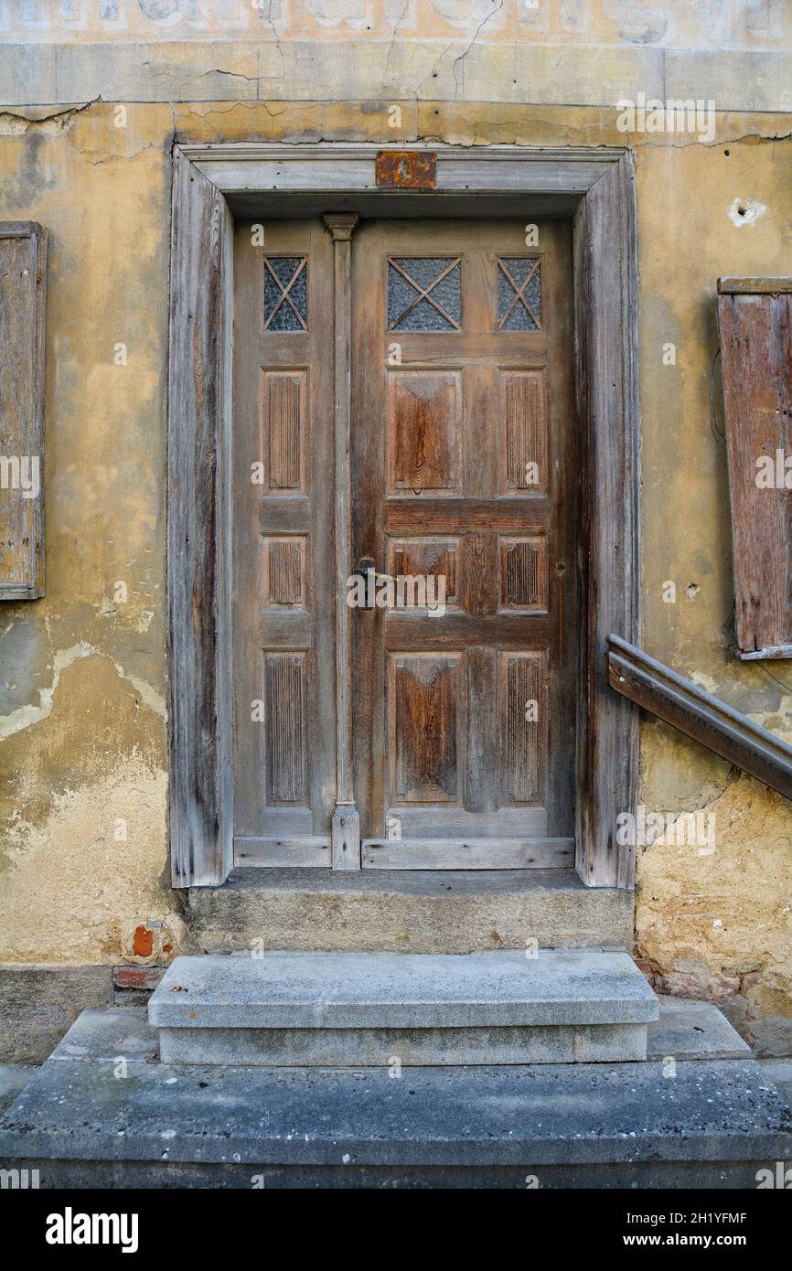 Una puerta vieja hecha de madera, con cristal y a pasos del exterior de una casa vieja Foto de stock