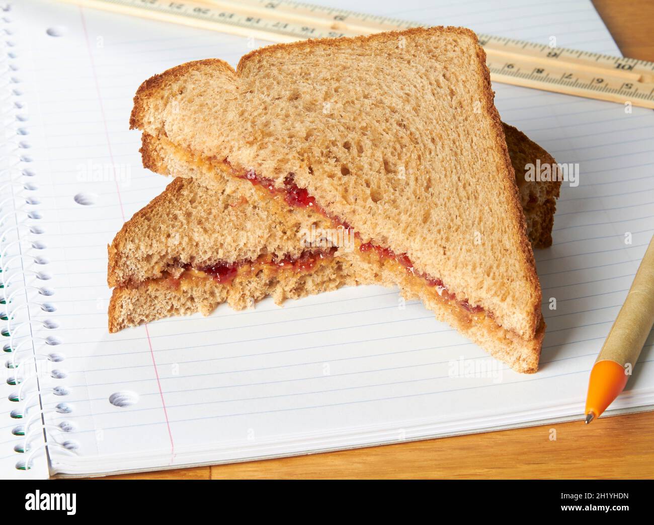 Una mantequilla de maní y sándwiches de mermelada en un cuaderno Foto de stock
