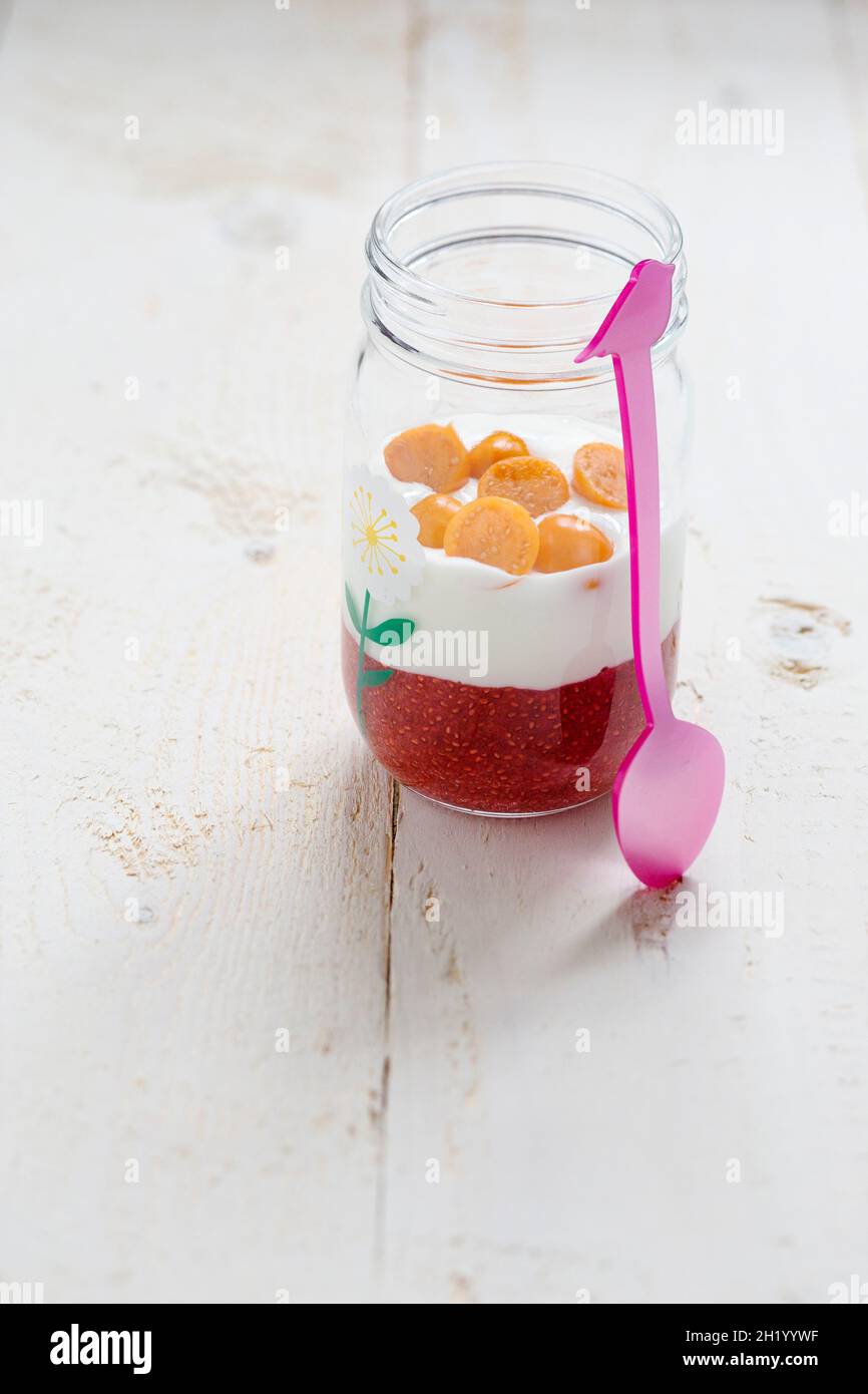 Una fresa la semilla de chía postre con yogur y physalis en un frasco de vidrio Foto de stock