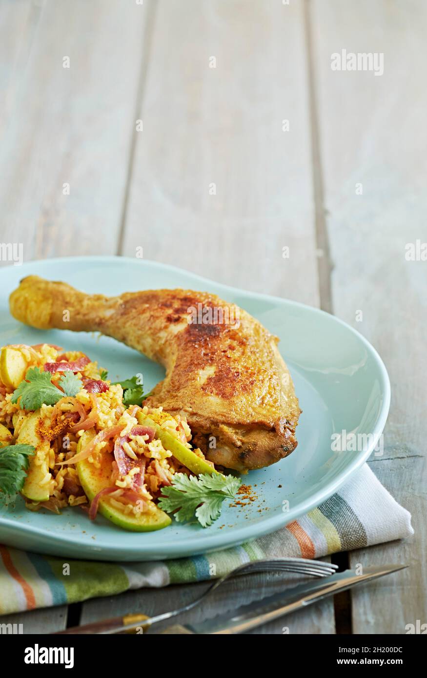 Arroz frito con curry y manzana servido con pata de pollo Foto de stock