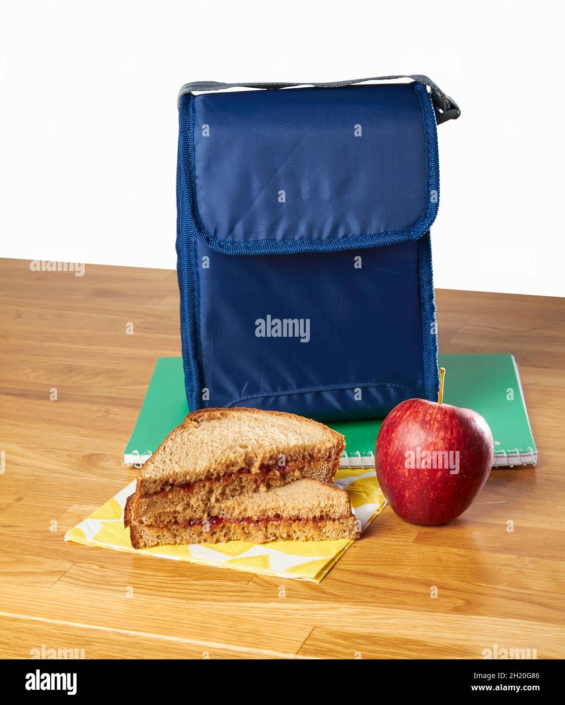 Un sándwich de mantequilla de maní y una manzana como aperitivo con una bolsa de almuerzo Foto de stock