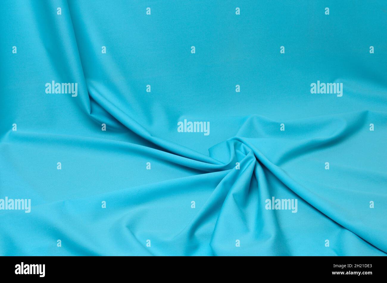 Fondo texturizado de tejido azul suave con pliegues elegantes. Enfoque selectivo. Foto de stock