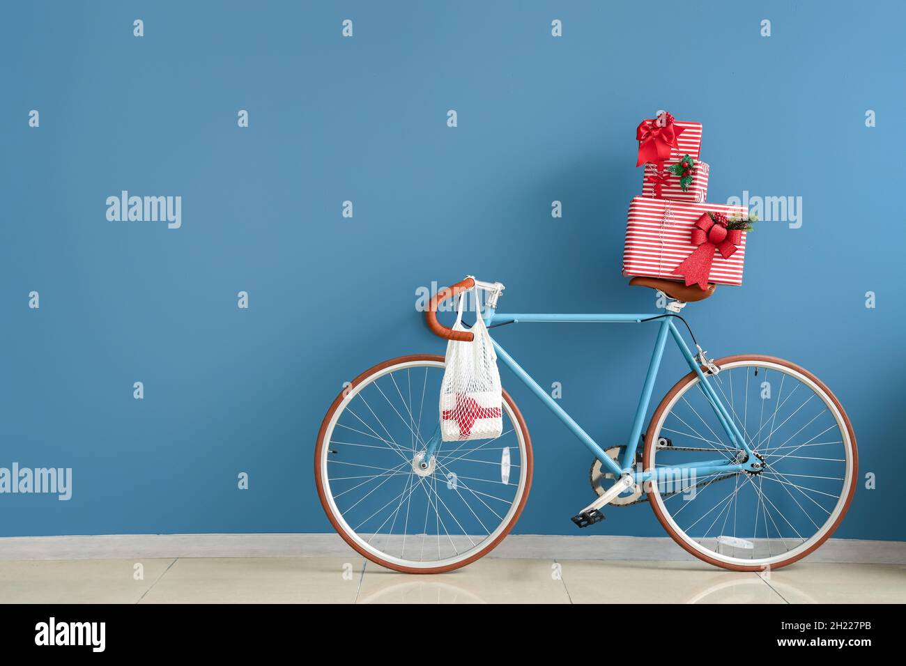 Bicicleta con hermosos regalos de Navidad cerca de la pared de color  Fotografía de stock - Alamy