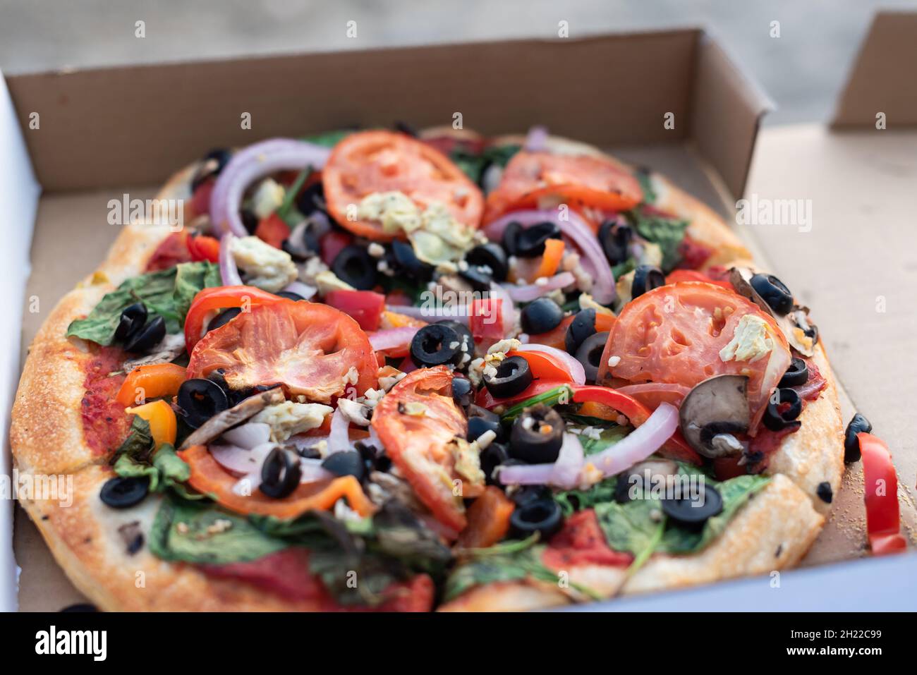 Primer plano de pizza vegana de estilo mediterráneo en una caja de pizza Foto de stock