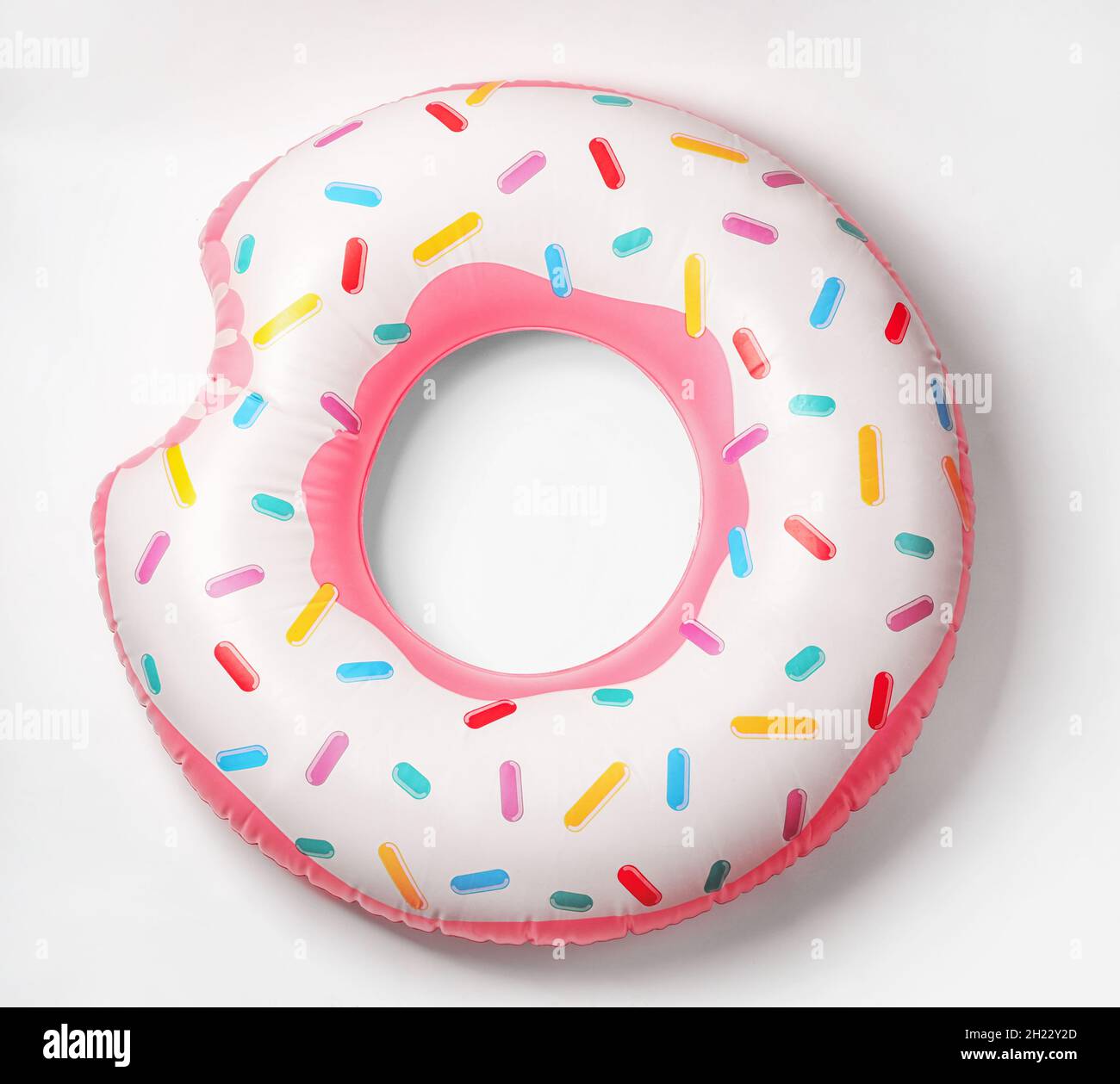 Donut inflable brillante sobre fondo blanco. Objeto de playa Foto de stock