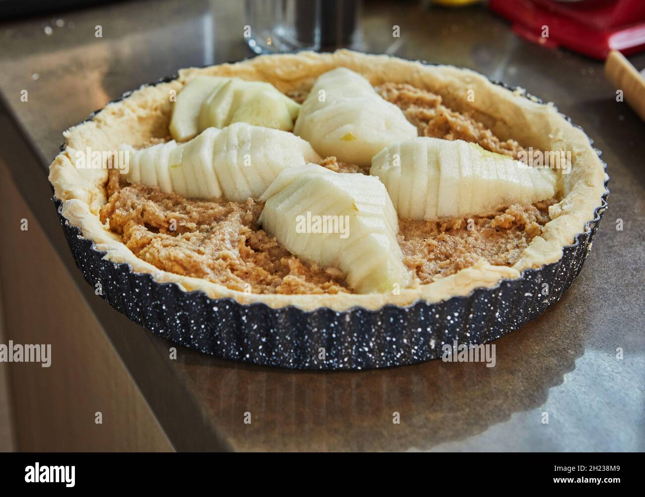 El pastel con peras y melocotones en molde metálico está listo para hornear  en un horno eléctrico Fotografía de stock - Alamy