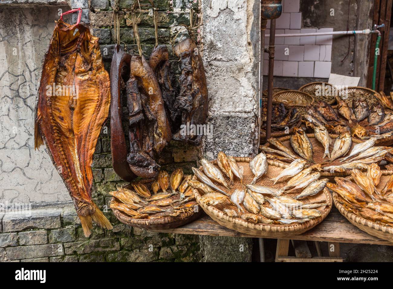 Tocino ahumado y pescado seco en venta en un mercado al aire libre en Furong, China. Foto de stock