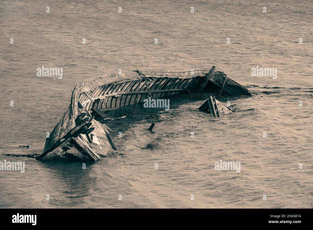Abandonado clinker construyó un barco parcialmente sumergido en una orilla del río Foto de stock