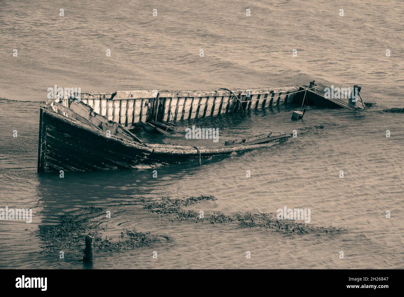 Abandonado clinker construyó un barco parcialmente sumergido en una orilla del río Foto de stock