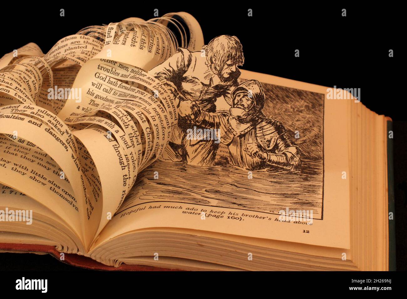 Escultura de libro hecha del progreso del peregrino por John Bunyan esperanzado rescatando a su hermano de ahogarse el arte de papel. Foto de stock
