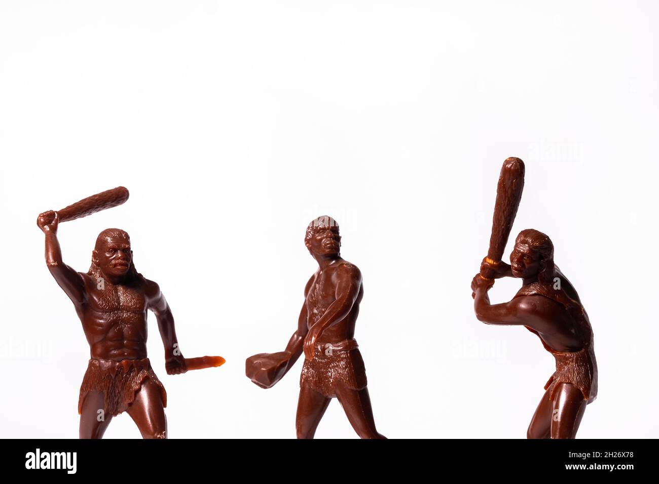 Grandes figuras de juguete de personas primitivas sobre un fondo blanco Foto de stock