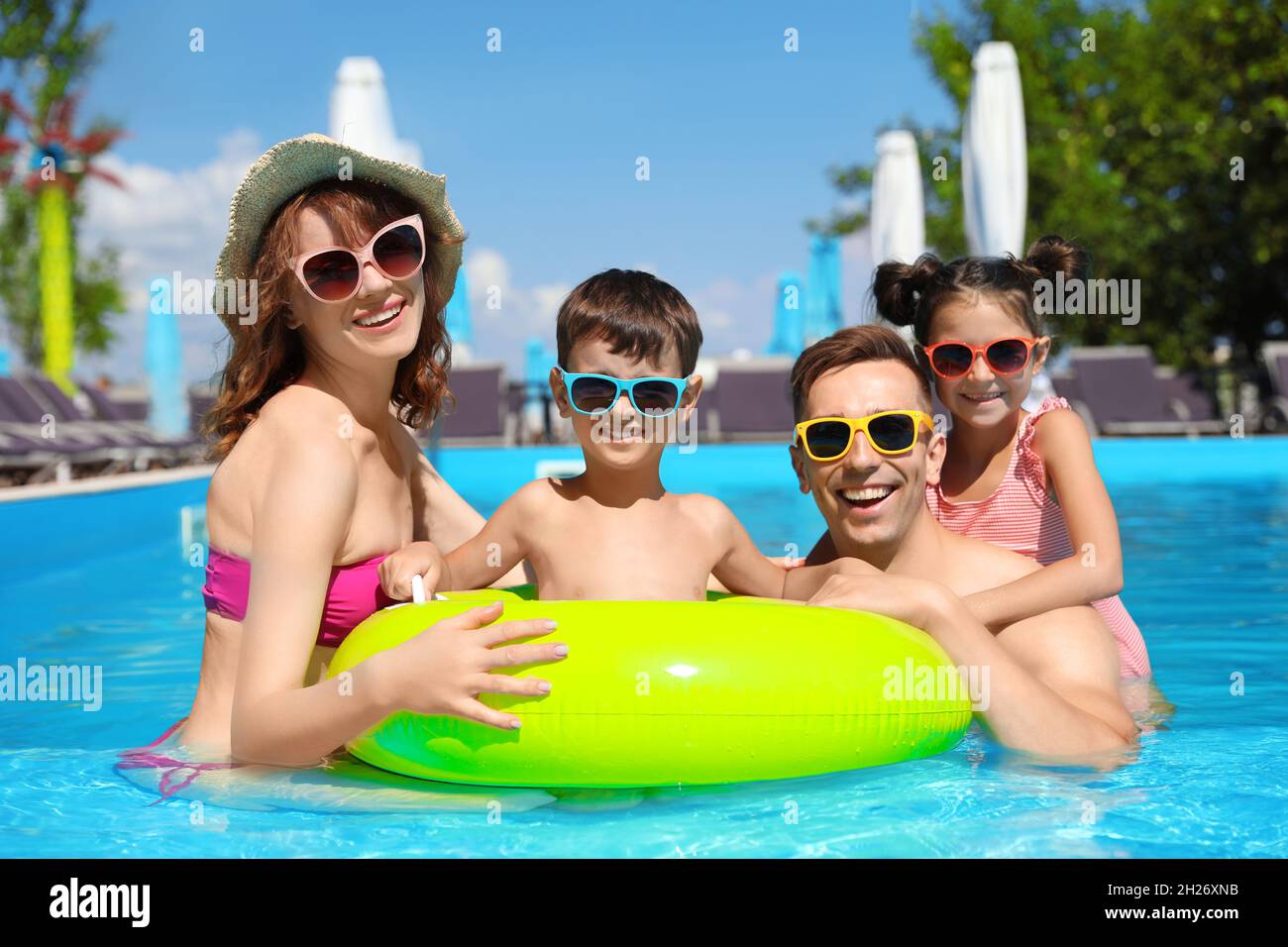 Feliz familia en la piscina del complejo Fotografía de stock - Alamy