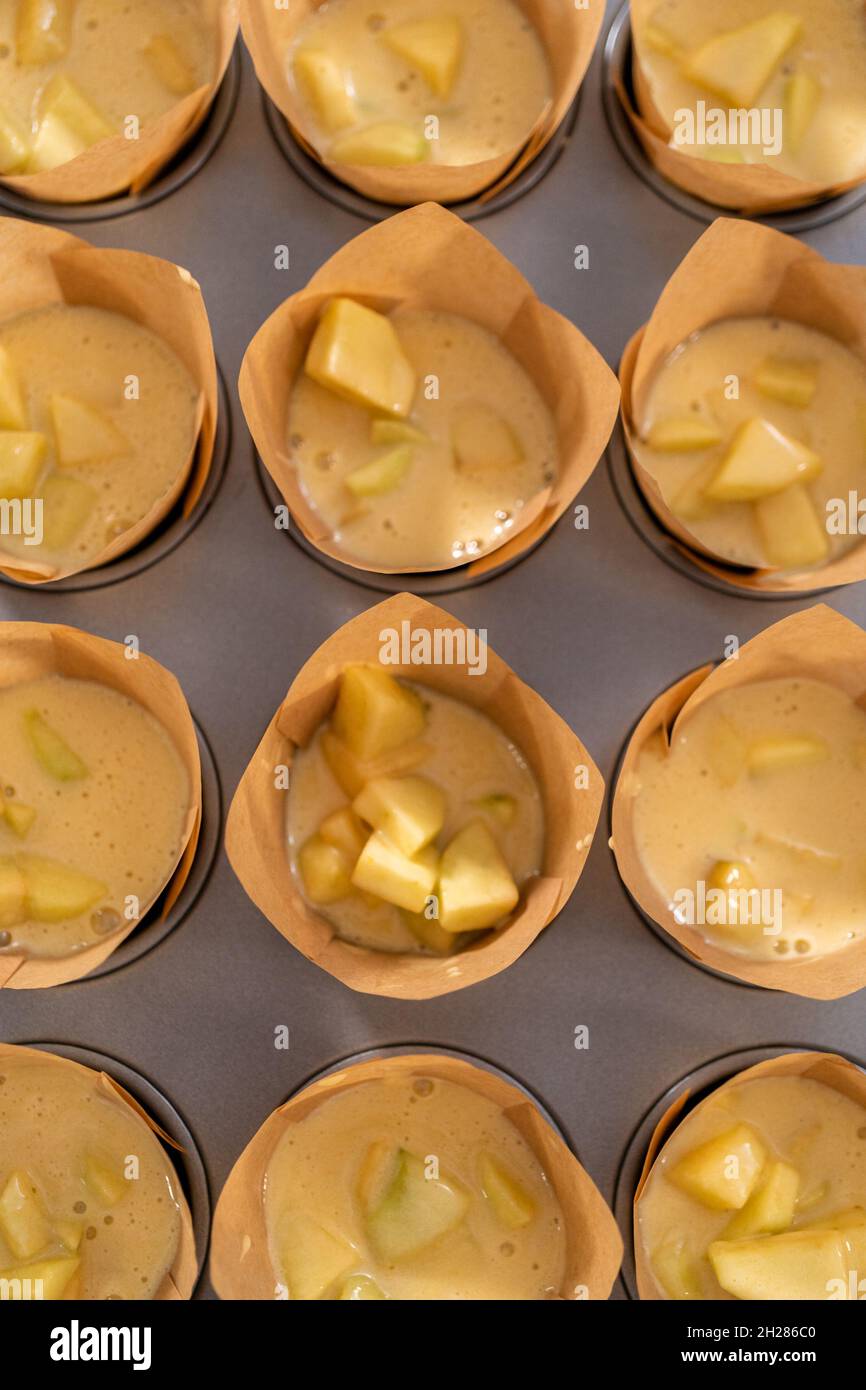 Recoge la masa en el recipiente para cupcakes con paneleras de papel para  hornear muffins sharlotka Fotografía de stock - Alamy
