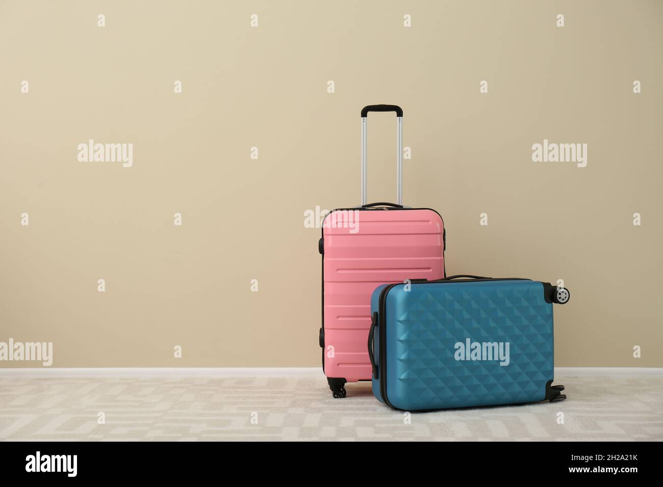 Maletas modernas en el suelo cerca de la pared. Espacio para texto  Fotografía de stock - Alamy