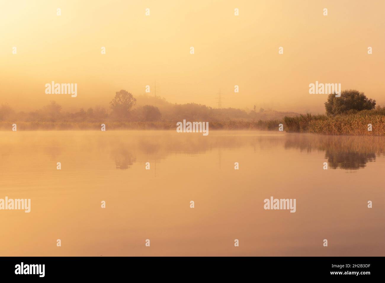 Luz naranja de la puesta de sol sobre el lago Sacalaia en Transilvania Foto de stock