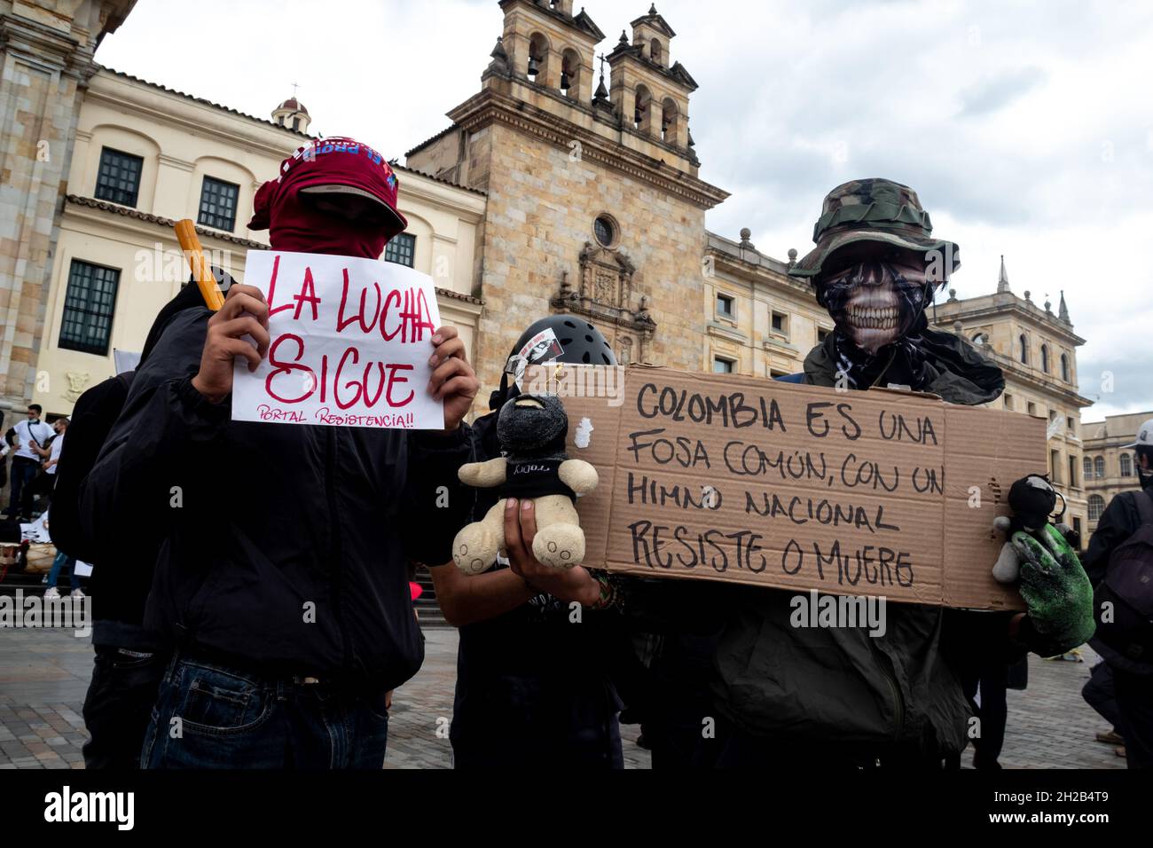 Bogotá, Colombia, 20 de octubre de 2021. Los manifestantes sostienen un letrero que dice 'Colombia es una fosa común con un himno nacional, para resistir o morir' durante una protesta contra las leyes y actos gubernamentales de Colombia en el Congreso. En Bogotá, Colombia, el 20 de octubre de 2021. Foto de stock