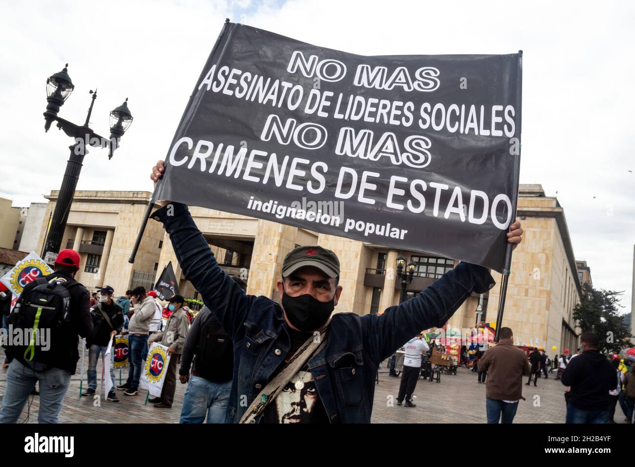 Bogotá, Colombia, 20 de octubre de 2021. Un manifestante con una señal que dice 'No más asesinatos y masacres de líderes sociales, no más crímenes estatales' durante una protesta contra las leyes y actos gubernamentales de Colombia en el Congreso. En Bogotá, Colombia, el 20 de octubre de 2021. Foto de stock
