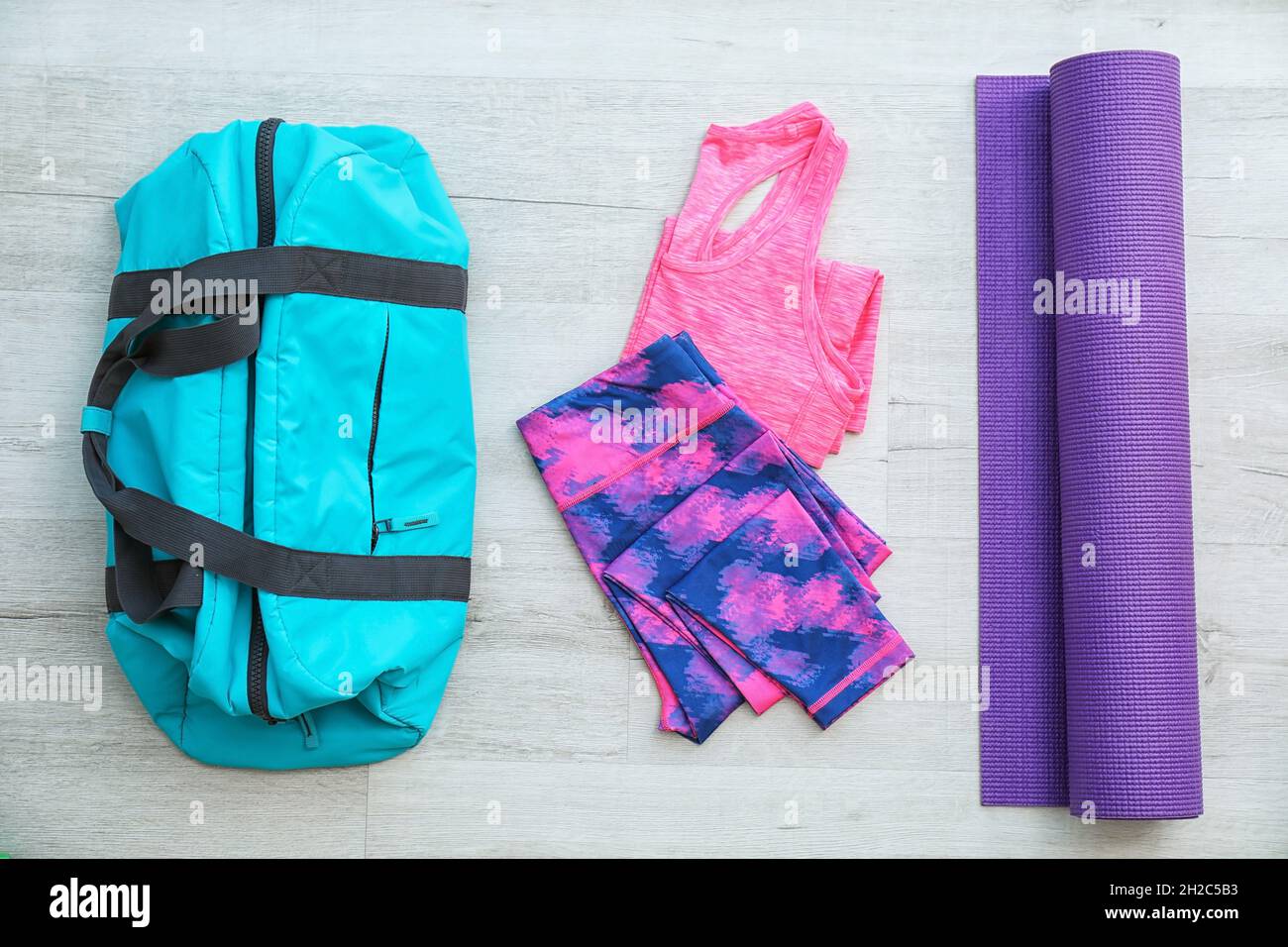 Composición plana con bolsa deportiva, ropa deportiva y alfombrilla sobre  suelo de madera Fotografía de stock - Alamy