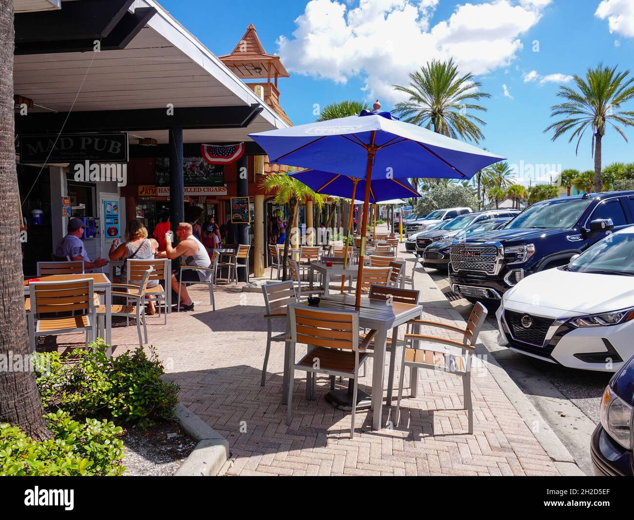 Mesas cubiertas con sombrilla, gente comiendo y bebiendo afuera en John's  Pass Village, Madeira Beach, Florida, Estados Unidos Fotografía de stock -  Alamy