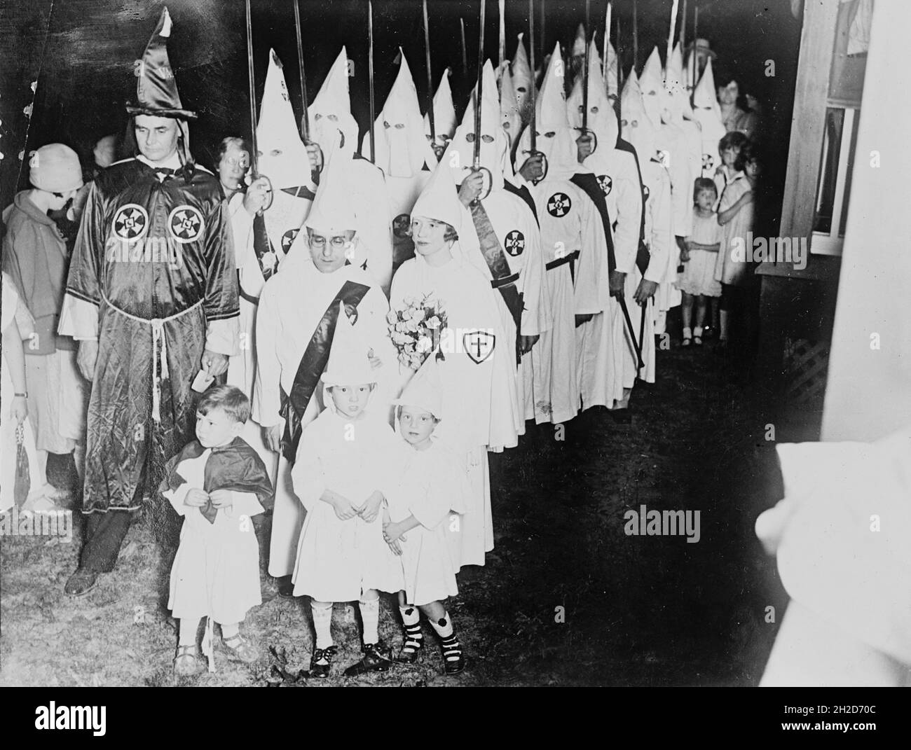Foto vintage alrededor de 1924 mostrando a los miembros del Ku Klux Klan asistiendo a una boda con niños pequeños vestidos con batas y capuchas klan Foto de stock