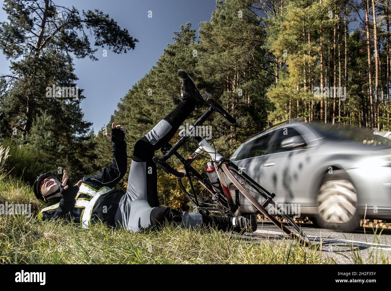 El accidente en una carretera de campo con caída de motociclista. Foto de stock