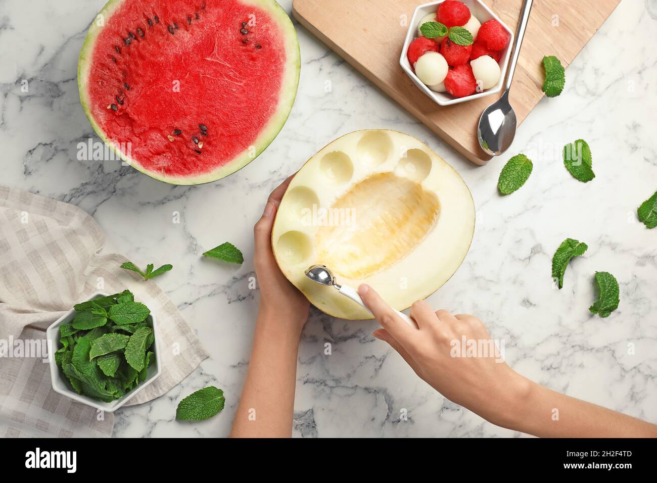 Mujer haciendo pelotas de melón en la mesa, vista superior Fotografía de  stock - Alamy