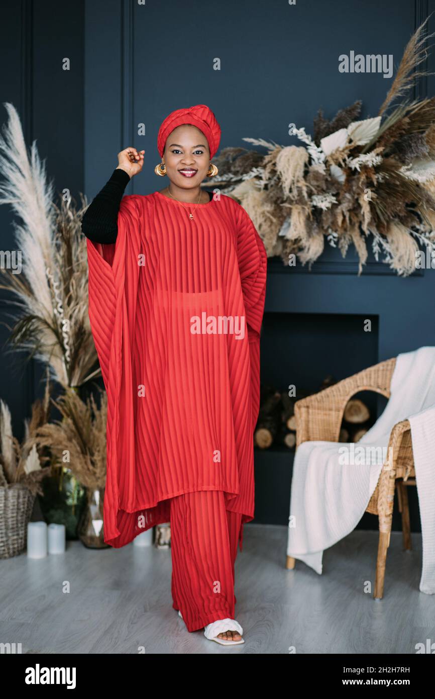 Orgullo mujer modelo africano con un vestido tradicional rojo y pañuelo en  la cabeza con brillante makupand joysly, posando en un estudio de estilo  tsylish Fotografía de stock - Alamy