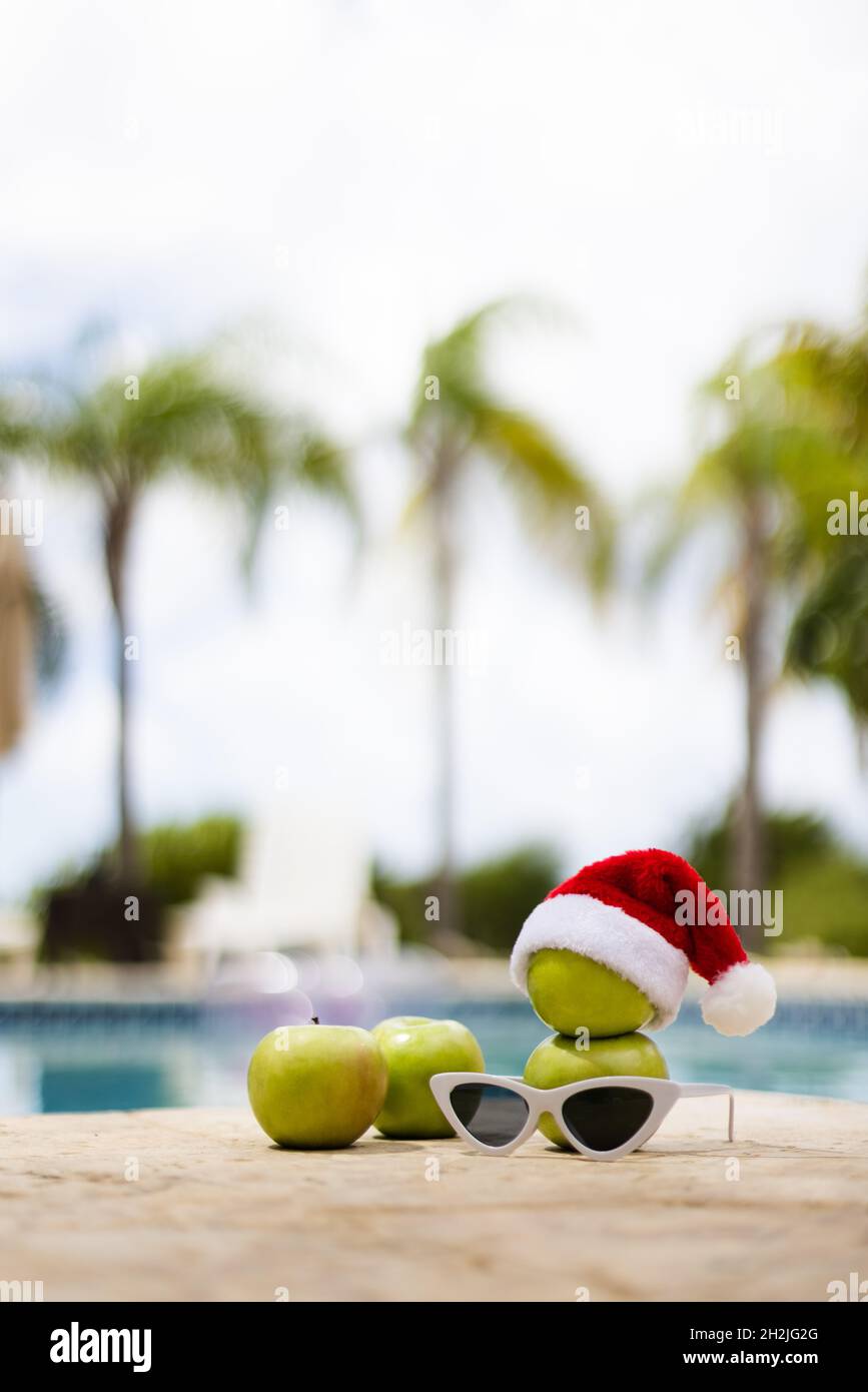 Muñeco de nieve hecho de manzanas en un sombrero de Navidad cerca de la piscina en el fondo de las palmeras. Enfoque fondo Fotografía de stock - Alamy