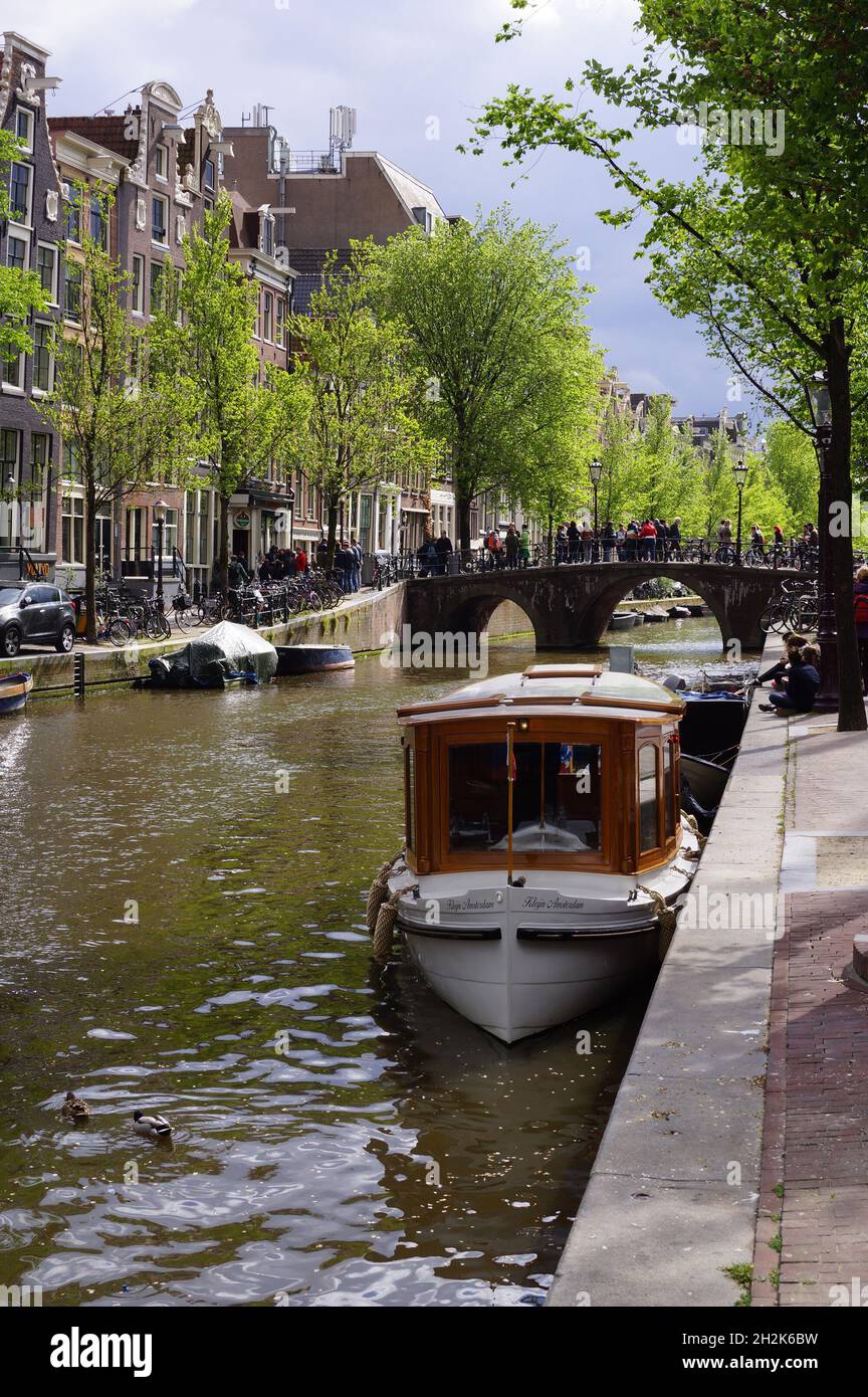 Amsterdam, Países Bajos: Un barco amarrado en un canal en el centro histórico Foto de stock