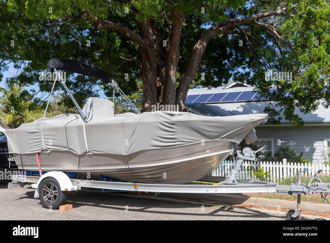 Barco en un remolque y cubierto estacionado en la calle Sydney en North Avalon,NSW,Australia Foto de stock