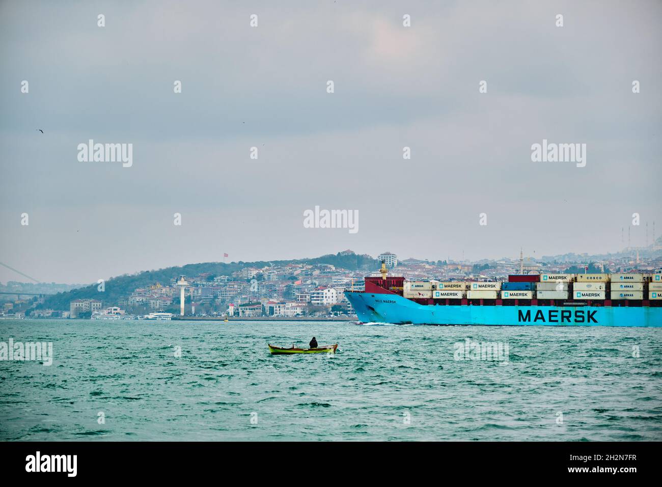 Ferry peatonal y barco de transporte de carga en bosporus temprano en la mañana en estambul en el cuerno de oro junto con un pequeño barco de pesca. Foto de stock