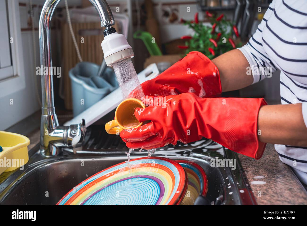 Mujer madura lavando la taza en el fregadero Foto de stock
