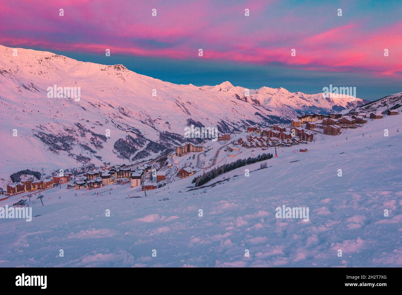 Pintoresco paisaje de invierno al amanecer, impresionante estación de esquí con casas típicas alpinas de madera en las pistas de los Alpes franceses, Les Menuires, 3 Vallees, Franc Foto de stock