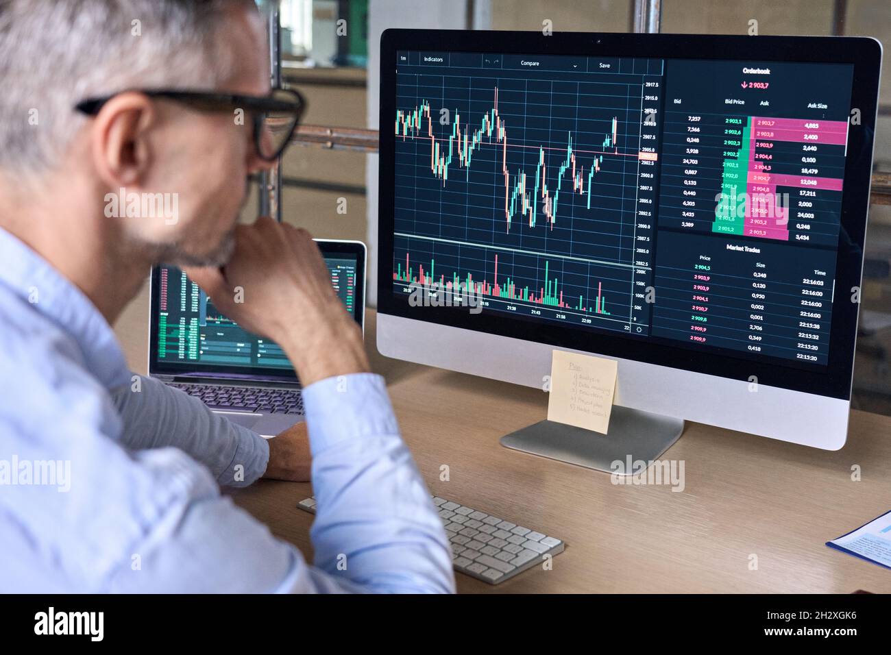 Crypto comerciante analista inversor mirando la computadora analizando datos en el monitor de pc. Foto de stock
