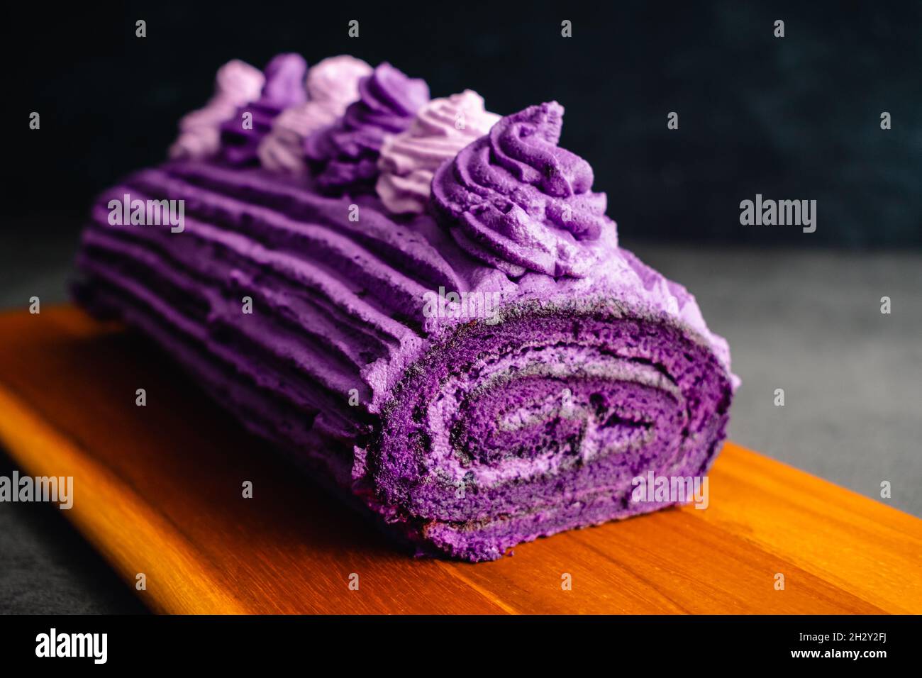 Rollo de pastel de Ube con crema batida Congelación: Roulade hecha con  patatas dulces púrpura y glaseado con nata montada Fotografía de stock -  Alamy