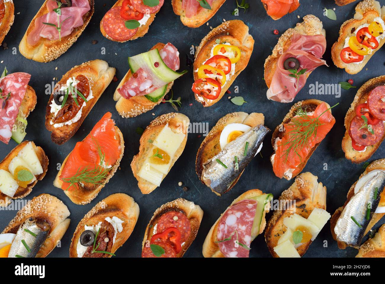 Deliciosas tapas españolas mixtas con especialidades típicas en baguette  asado con sésamo sobre un fondo oscuro Fotografía de stock - Alamy