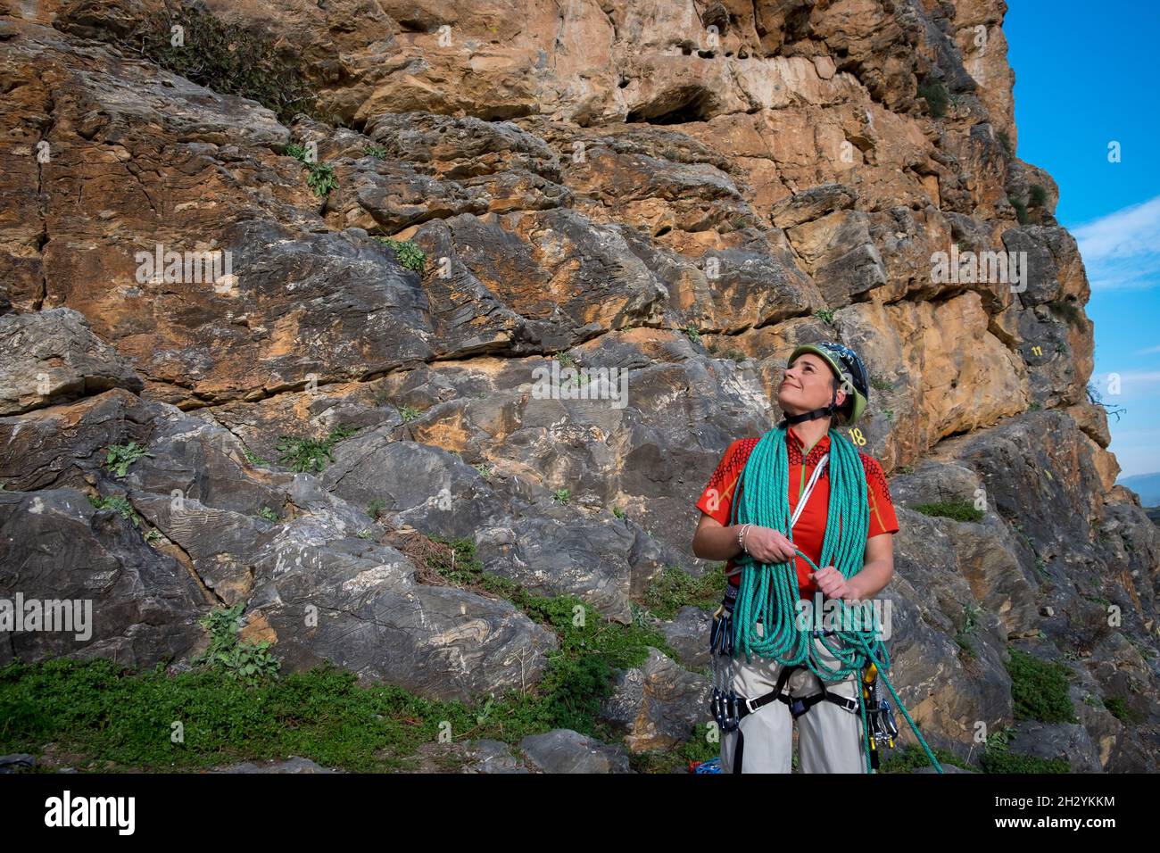 Escalador de roca femenina que enrolla la cuerda Foto de stock