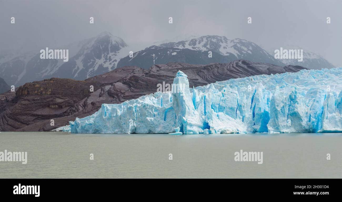 Panorama glaciar gris con flujo de lava y picos de la montaña de los Andes en la niebla, Parque Nacional Torres del Paine, Patagonia, Chile. Foto de stock